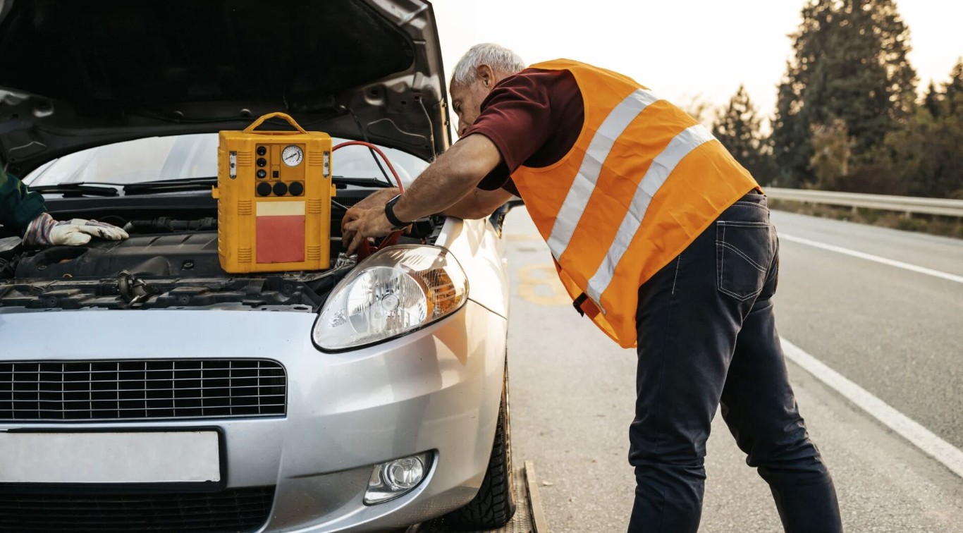 Professional roadside assistance mechanic helping stranded motorist